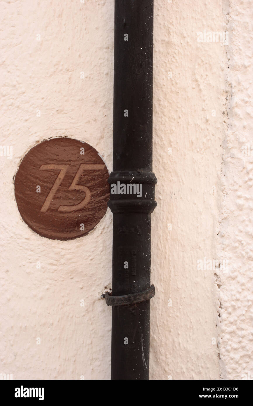 La porte numéro 75 en céramique fixé sur un mur extérieur à Crail, Fife Banque D'Images