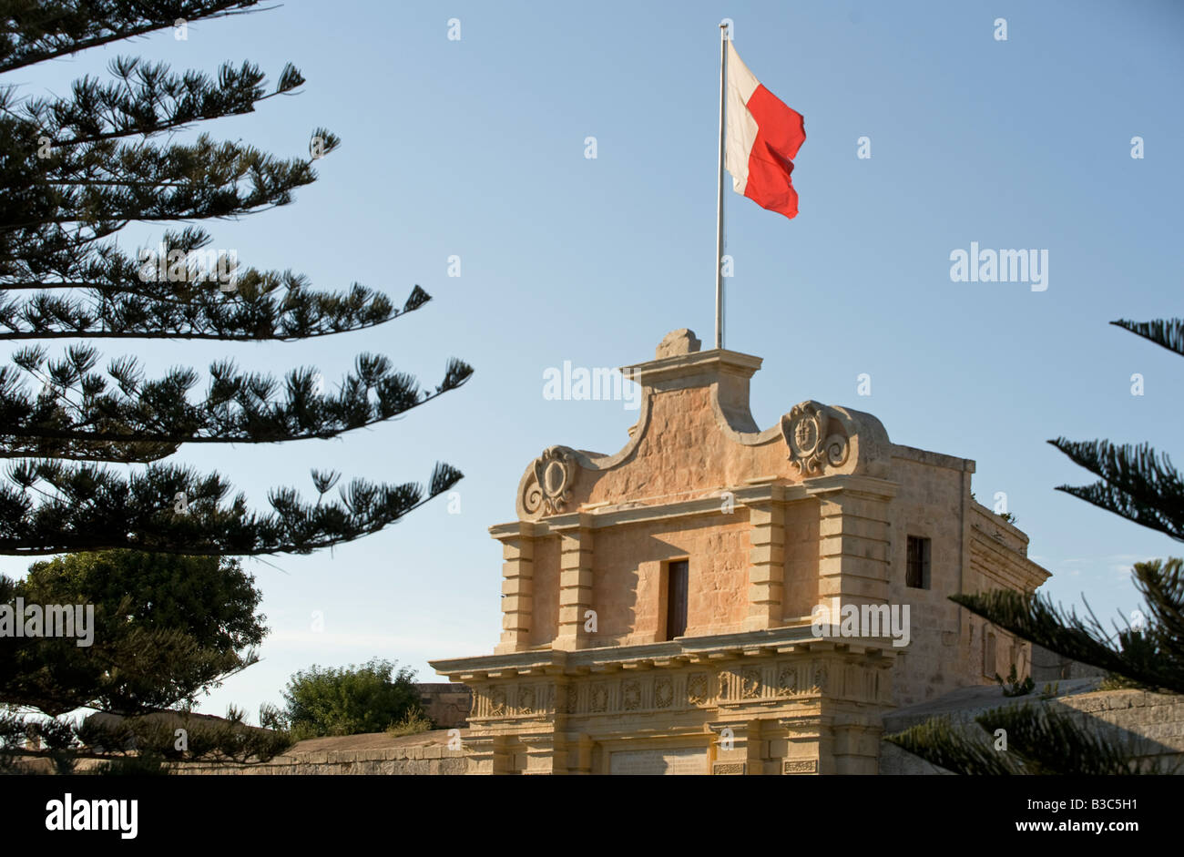 Malte, Mdina. Le pavillon maltais vole au-dessus de l'entrée de la ville fortifiée médiévale de Mdina. Banque D'Images