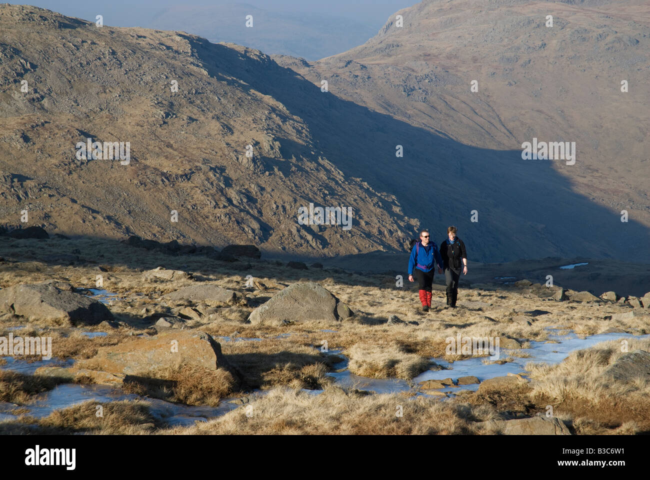 L'Angleterre, Cumbria, Lake District. Les promeneurs traversant les Langdale Pikes, à Langdale. Banque D'Images