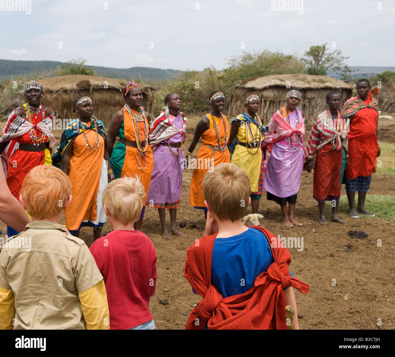 Kenya, Masai Mara National Reserve. Les enfants sur une famille visite safari un Masaï manyatta ou village juste en dehors de la réserve. Banque D'Images