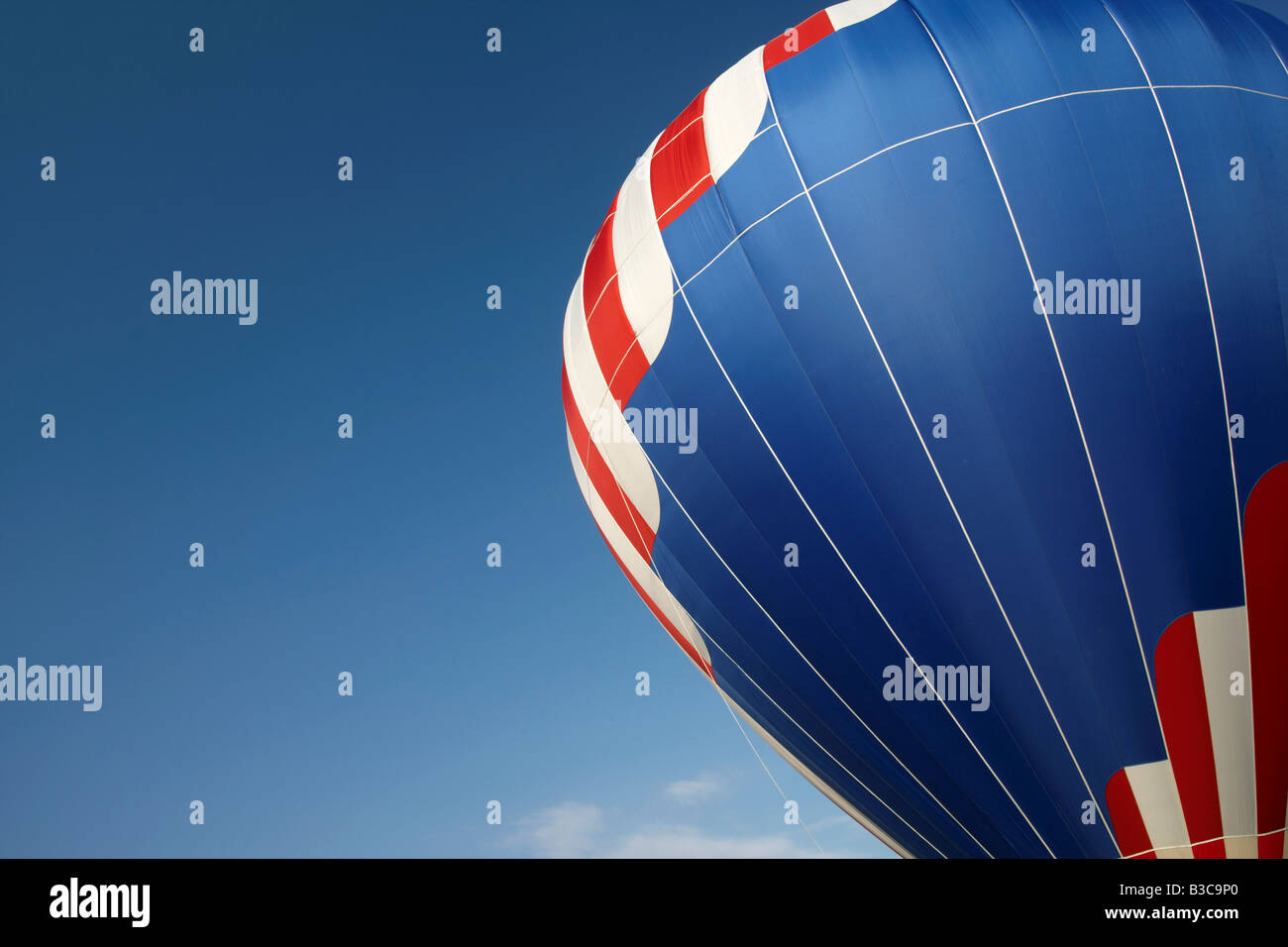Un ballon à air chaud coloré contre un ciel bleu clair Banque D'Images