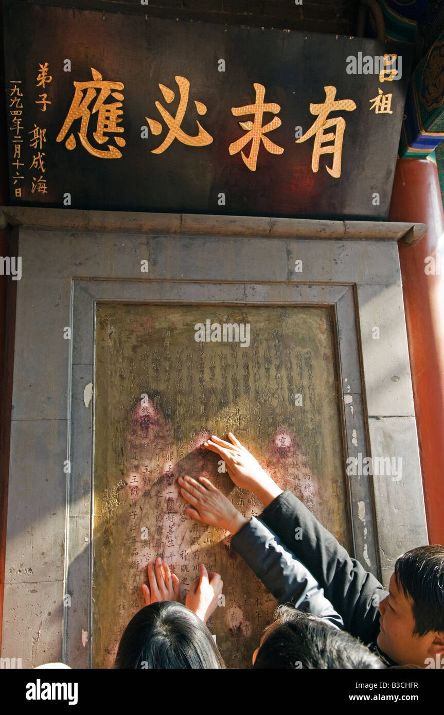 La Chine, Beijing. Nouvel An chinois - Festival de Printemps sacré insriptions fidèles de toucher au Baiyun Guan Temple taoïste du nuage blanc. Banque D'Images