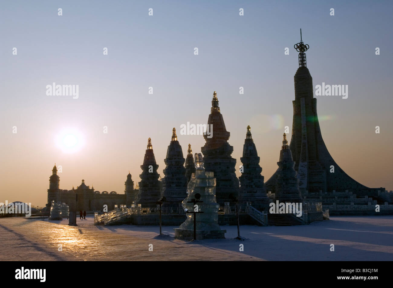 La Chine, le nord-est de la Chine, Heilongjiang Province, ville de Harbin. Festival de lanternes de glace. Coucher du soleil sur la reproduction de sculpture de Bangkok Wat Po. Banque D'Images