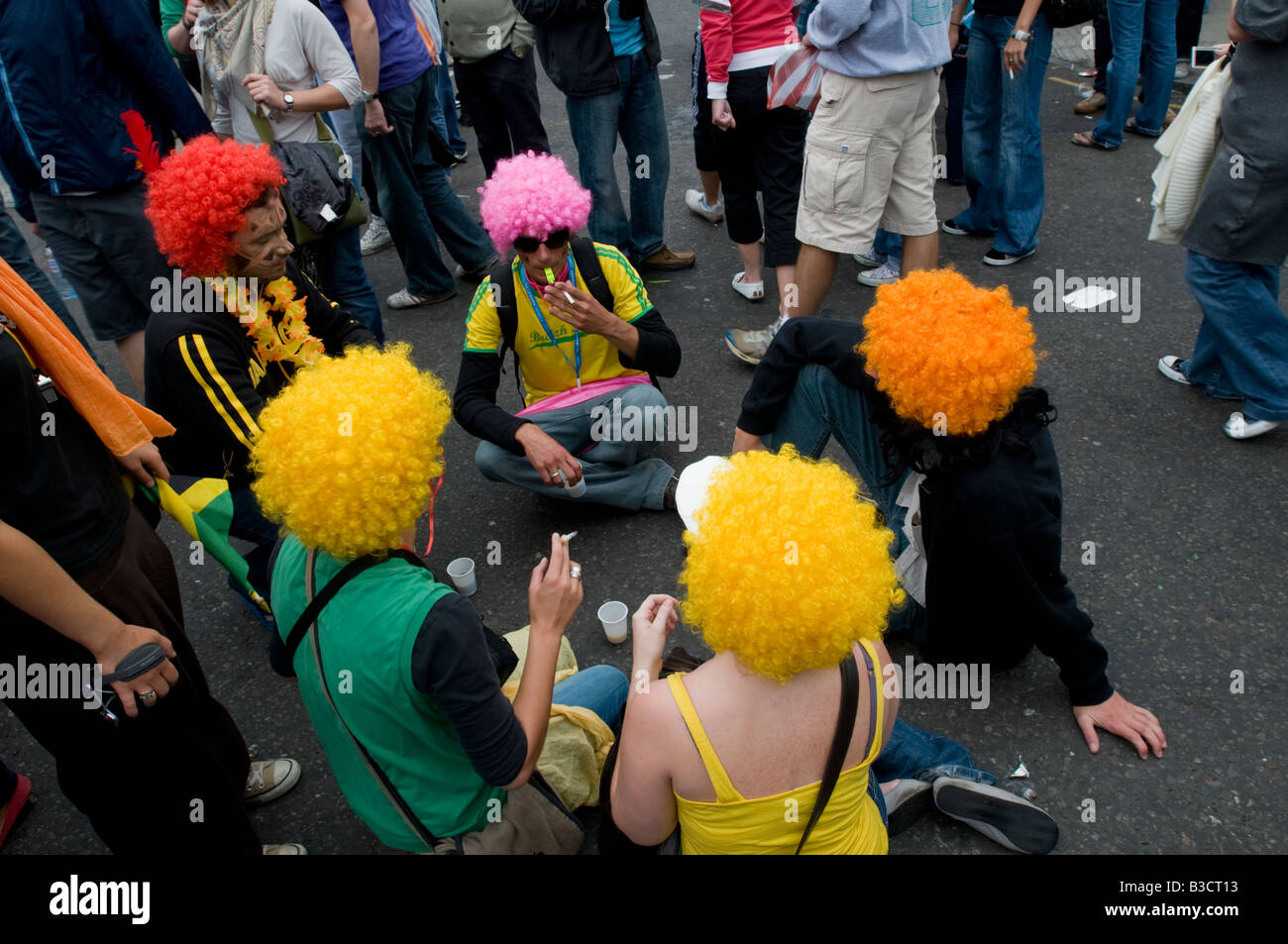 Royaume-uni, Angleterre, 25 août 2008. Fêtards s'asseoir dans la rue pendant la carnaval de Notting Hill dans l'ouest de Londres. Banque D'Images