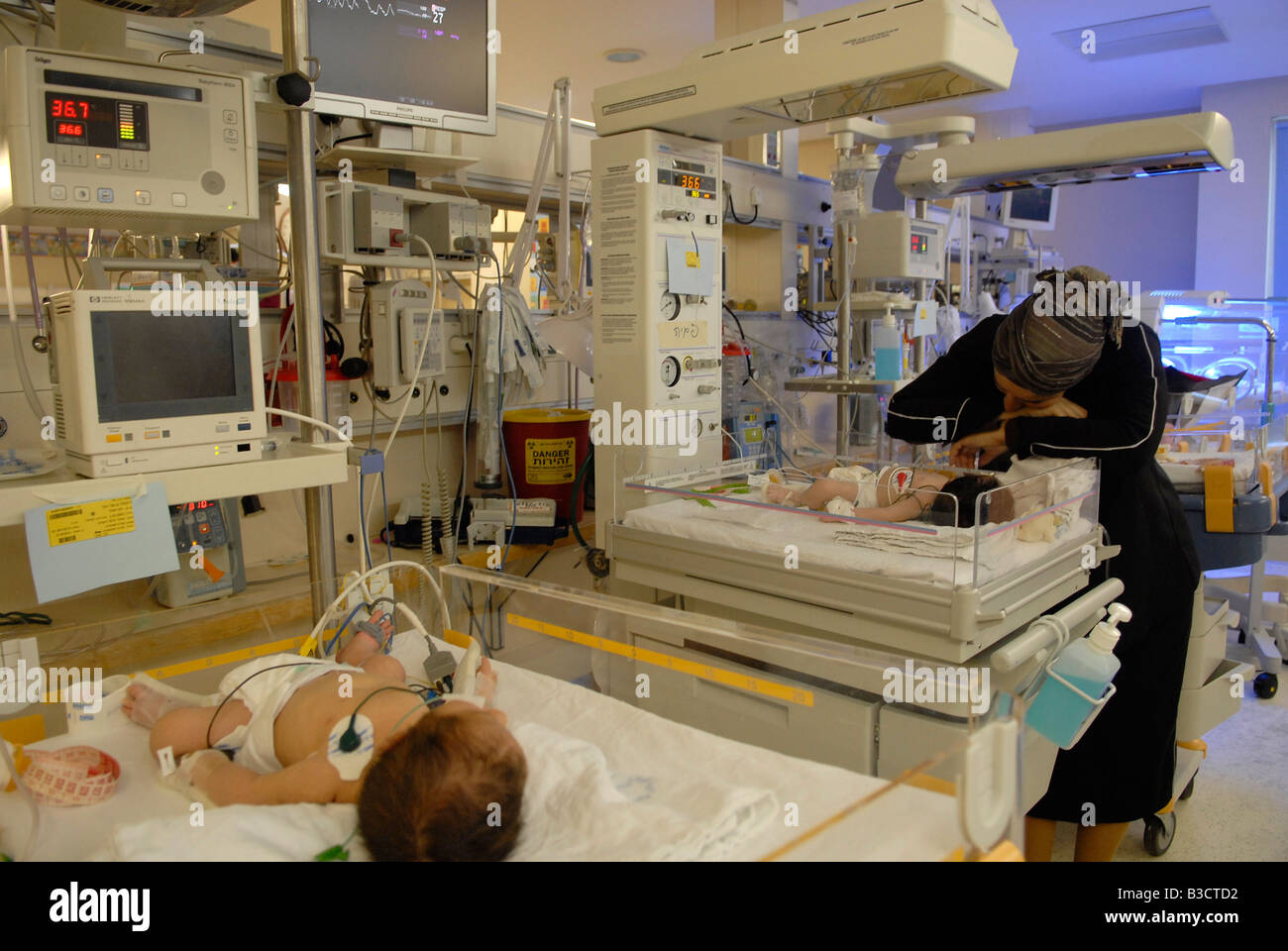 Femme religieuse inspectant son prématuré aux soins intensifs néonatals Unité Centre médical Shaare Zedek ou hôpital Shaarei Tzedek Ouest Jérusalem Banque D'Images