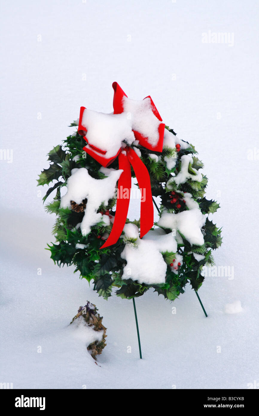 Couronne de Noël couvert de neige dans cimetière durant tempête Banque D'Images