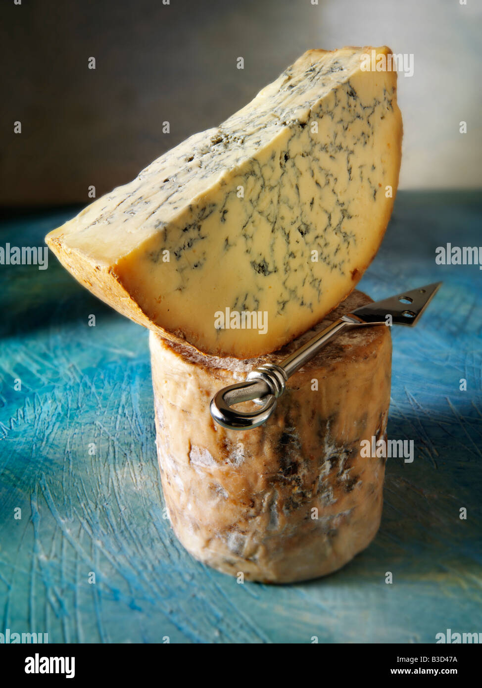 Fromage Stilton frais entier et coupé dans un cadre rustique nourriture encore vie Banque D'Images