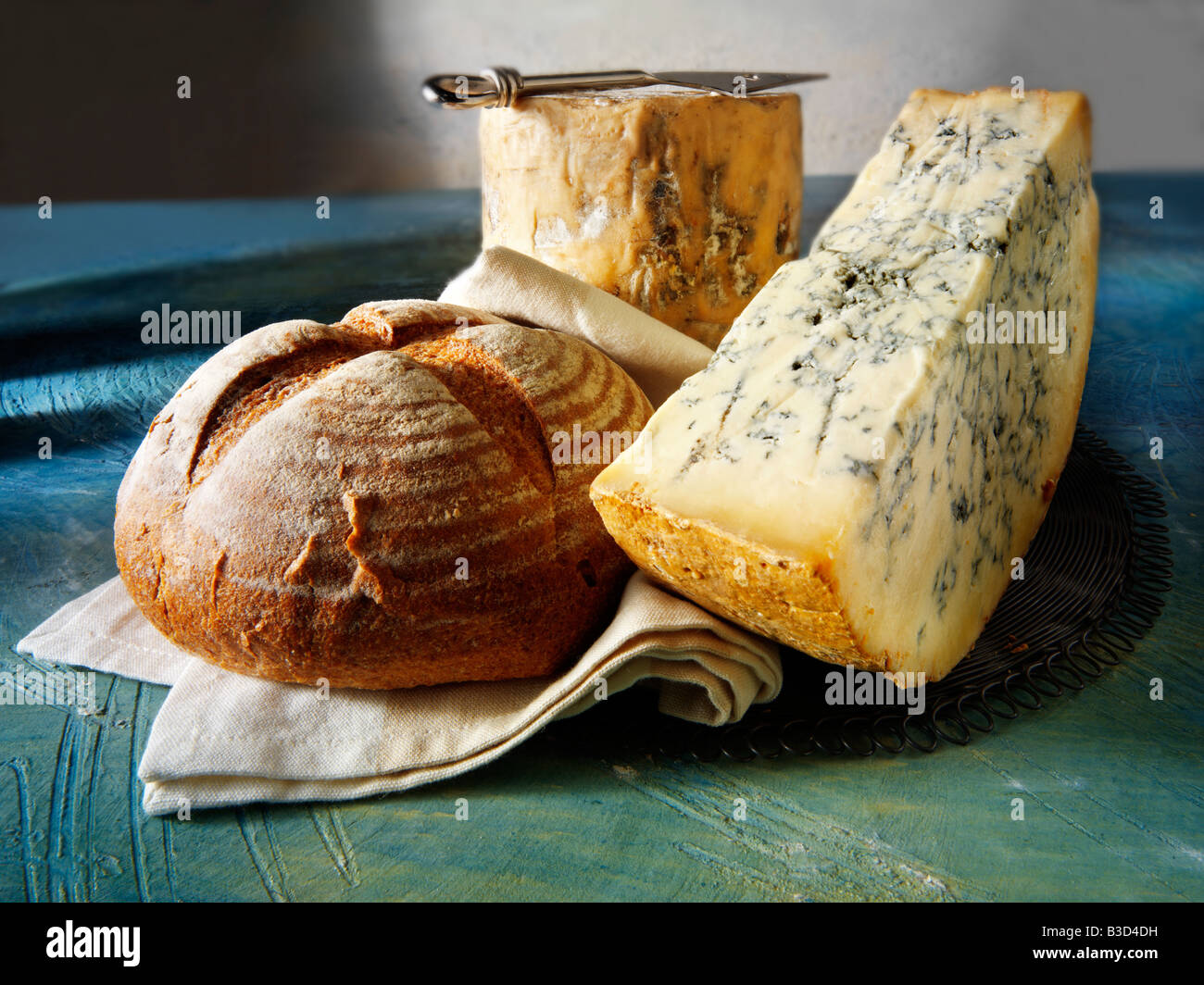 Fromage Stilton frais entier et coupé dans un cadre rustique nourriture encore vie Banque D'Images
