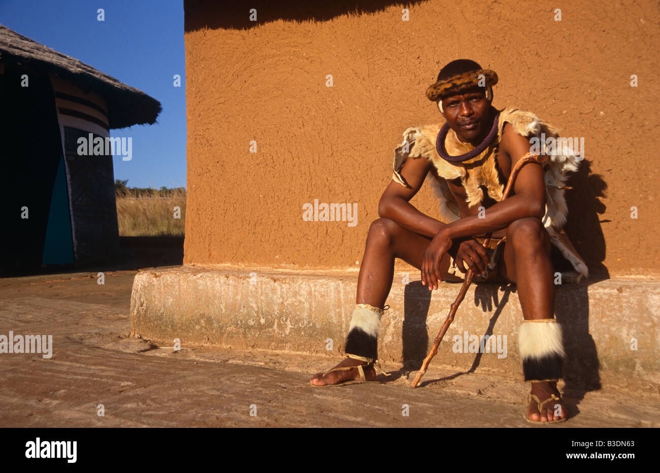 L'homme à l'extérieur de sa hutte Ndebele en Afrique du Sud. Banque D'Images