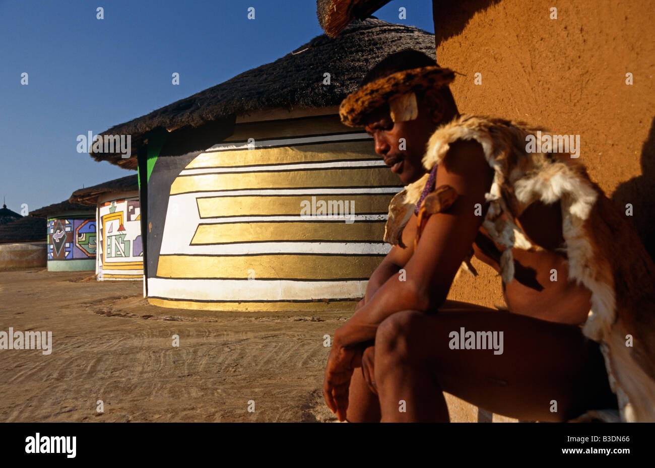 L'homme à l'extérieur de sa hutte Ndebele en Afrique du Sud. Banque D'Images