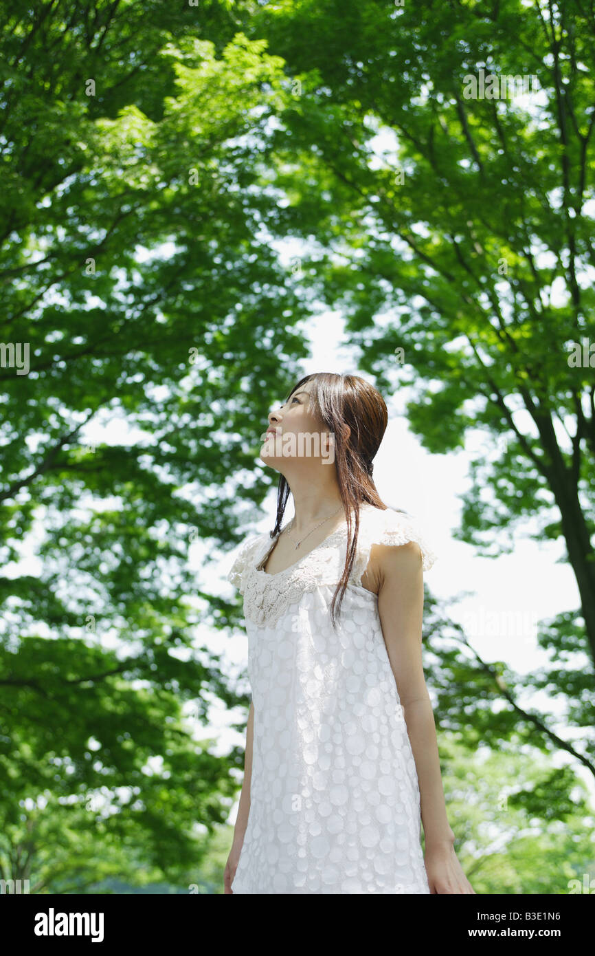 Une jeune femme à la recherche de vert des arbres Banque D'Images