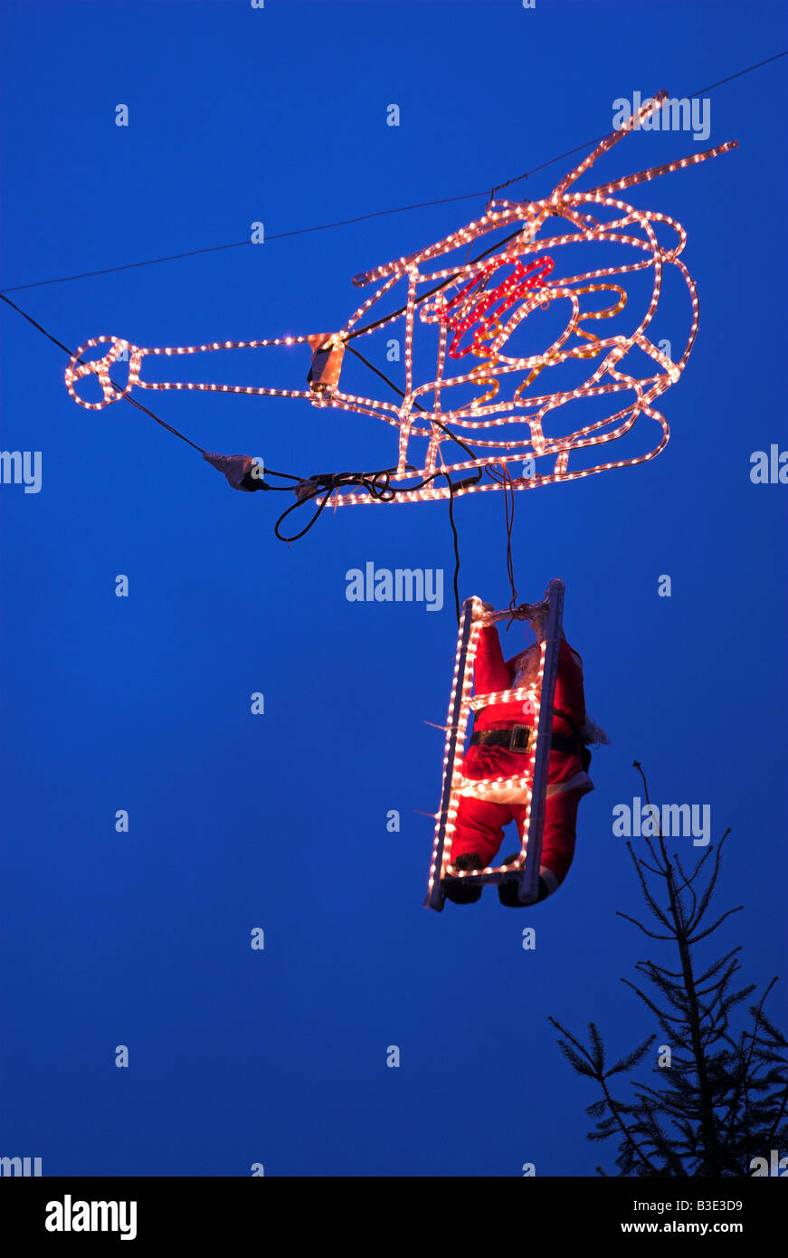 Ariel Vue de nuit allumé en hélicoptère et Santa Clause de grimper à bord de traîneau Banque D'Images