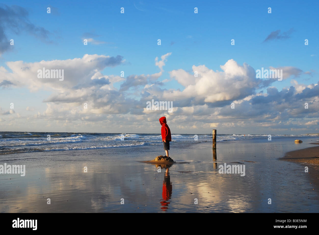 Scène de plage avec petit garçon en rouge Banque D'Images