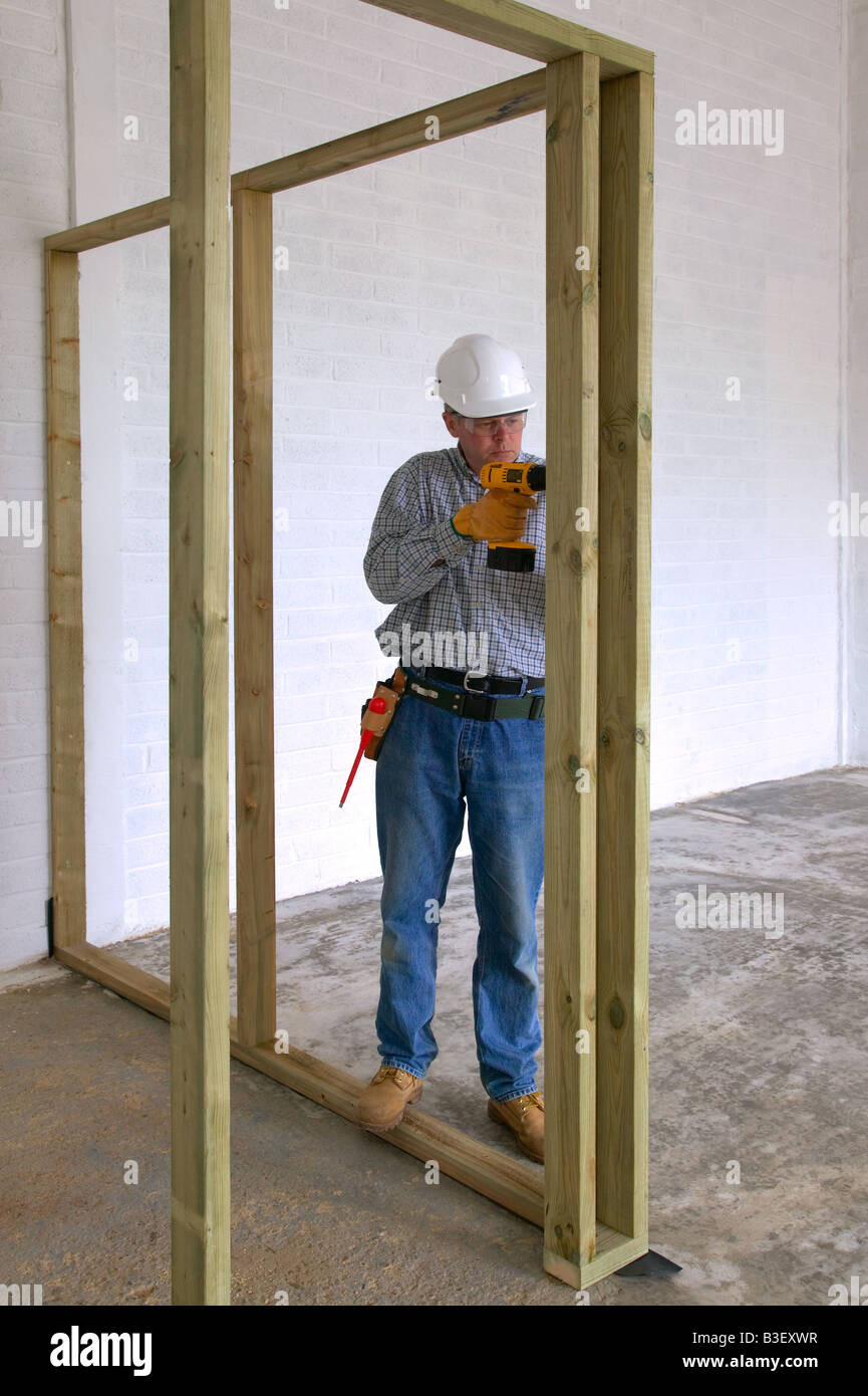 Carpenter le perçage dans le cadre du bois dans une maison neuve construire Banque D'Images