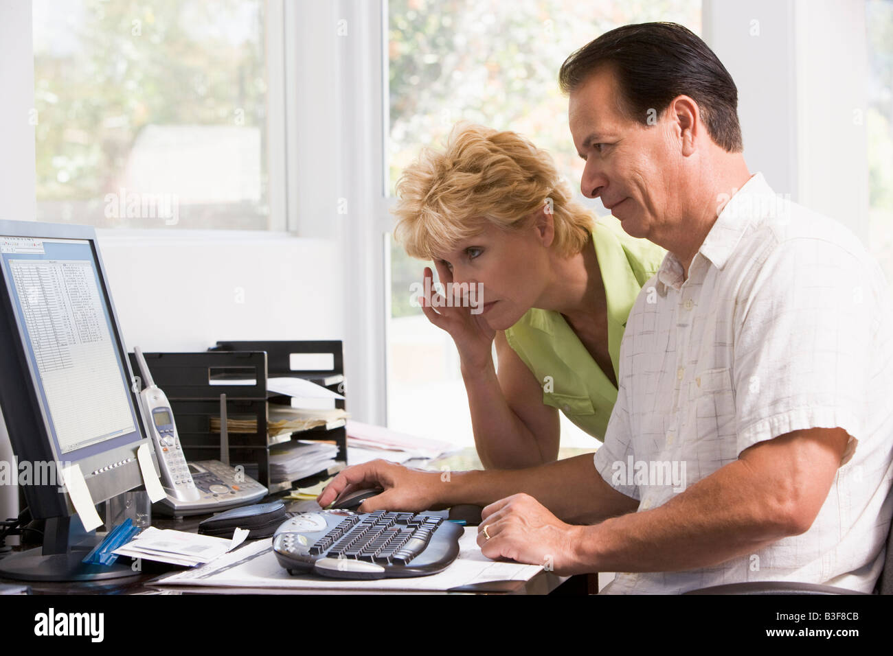 Couple in home office à l'ordinateur de froncer Banque D'Images