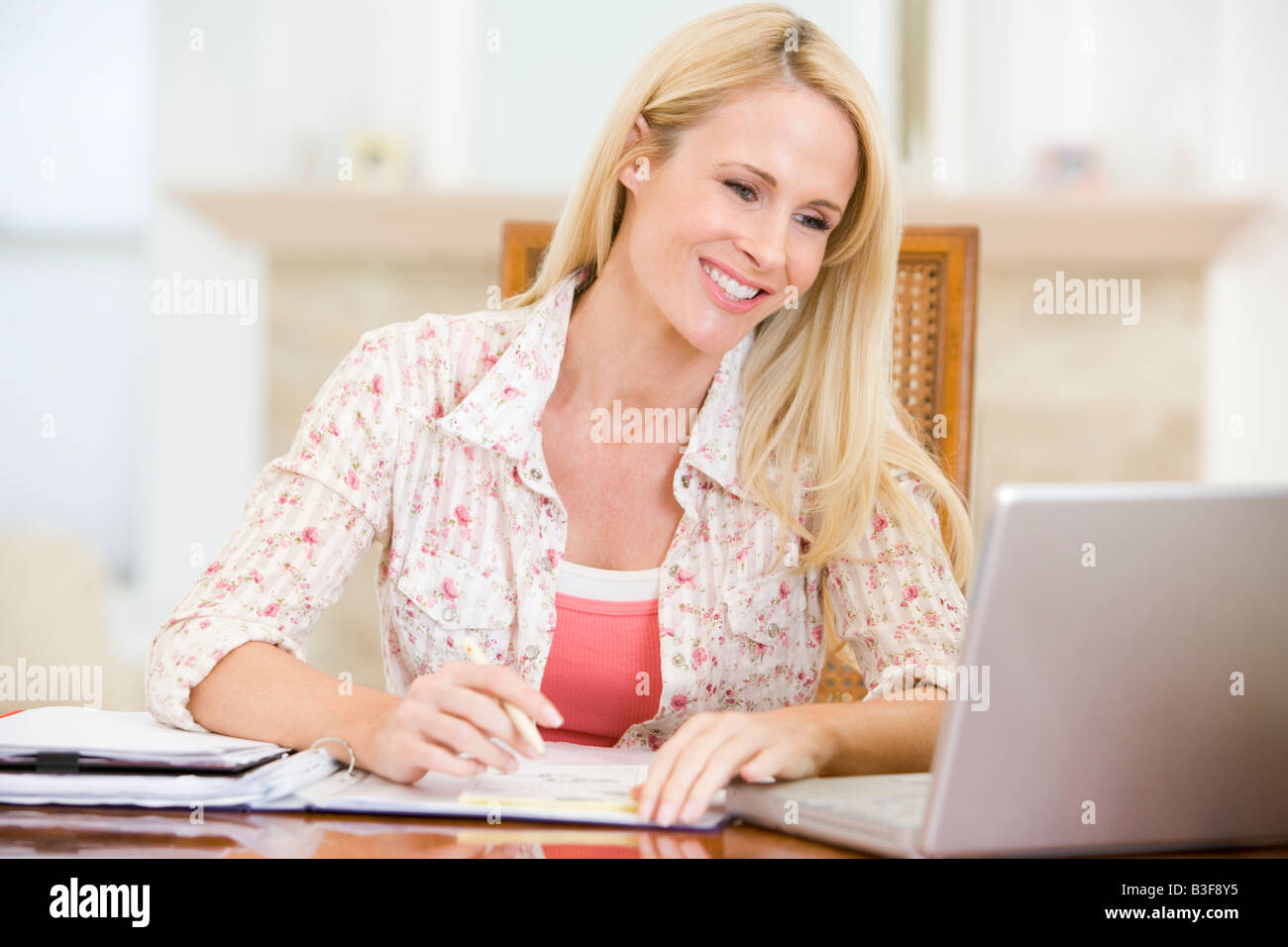 Femme de salle à manger avec laptop smiling Banque D'Images