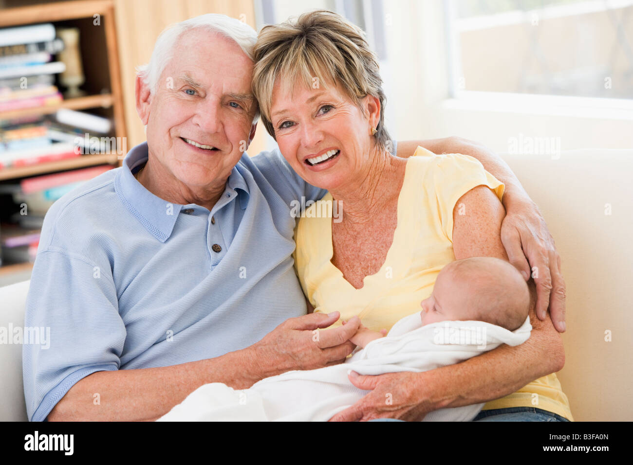 Les grands-parents dans la salle de séjour avec baby smiling Banque D'Images