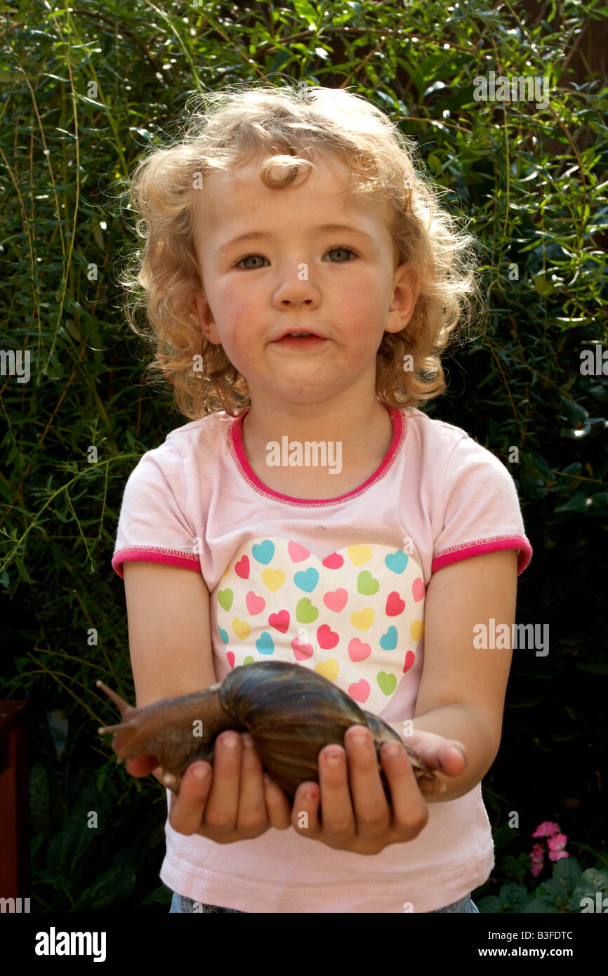 Girl holding african land snail Banque D'Images