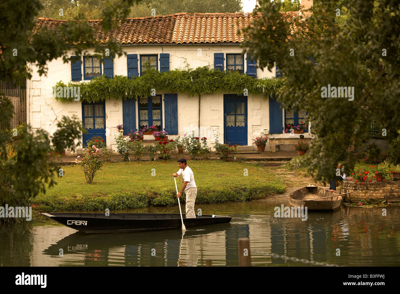 Homme dans un bateau près de la rivière chalet Coulon Marais Poitevin Poitou Charentes France Europe Banque D'Images