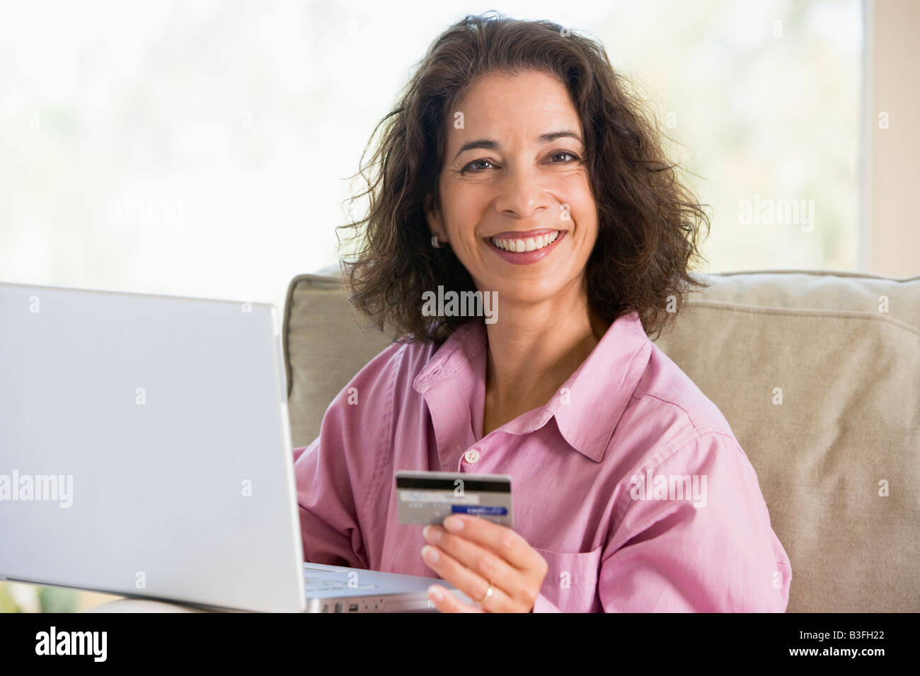 Femme avec un ordinateur portable faire un achat en ligne par carte de crédit Banque D'Images Femme avec un ordinateur portable faire un achat en ligne par carte de crédit Banque D'Images