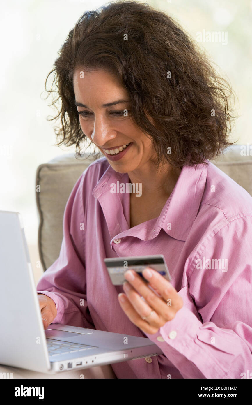 Femme avec un ordinateur portable faire un achat en ligne par carte de crédit Banque D'Images Femme avec un ordinateur portable faire un achat en ligne par carte de crédit Banque D'Images