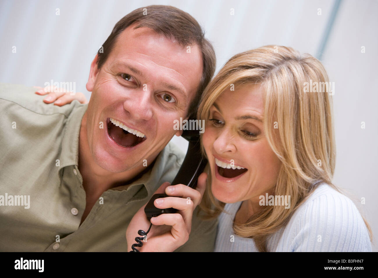 Couple recevant une bonne nouvelle appel téléphonique de la clinique Banque D'Images