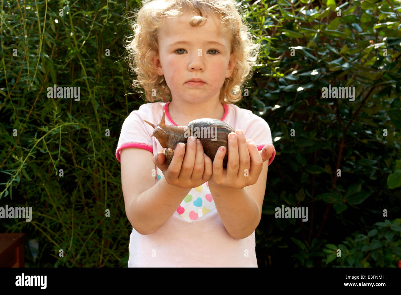 Girl holding african land snail Banque D'Images