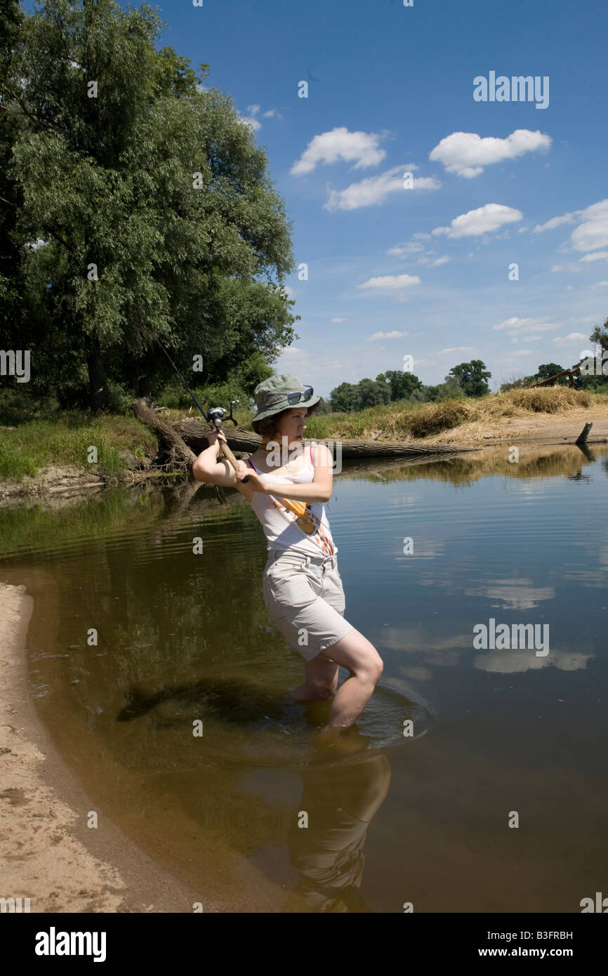 Jeune femme à la pêche dans un canal de l'odeur d'Odra, dans l'ouest de la Pologne Banque D'Images