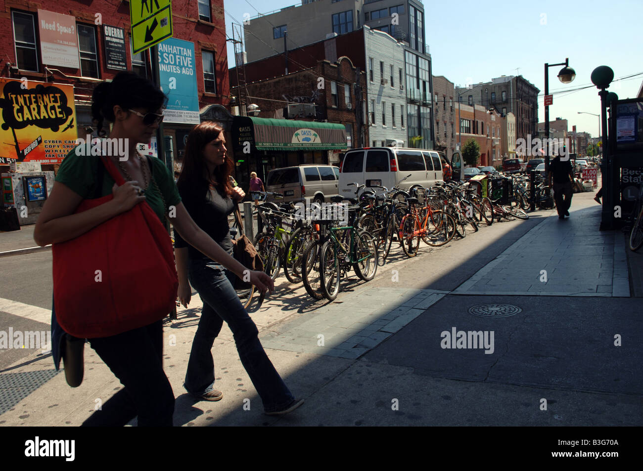 Les piétons à pied des motos garées à la station de métro de l'avenue Bedford à Williamsburg à Brooklyn à New York Banque D'Images