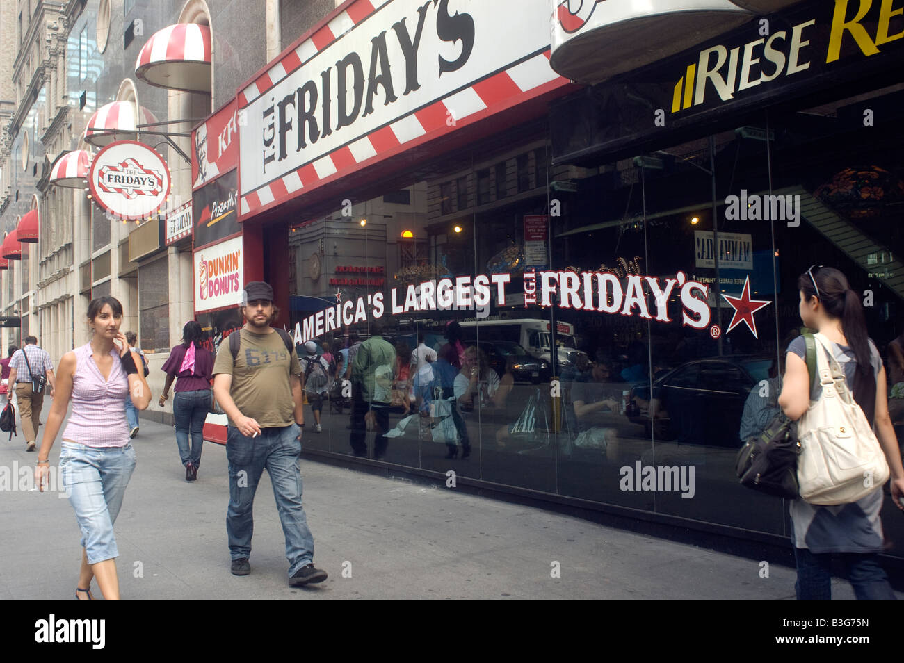 Les piétons se promener par un ensemble de concessions contrôlées par Riese Restaurants situé dans l'un storefront à Times Square Banque D'Images