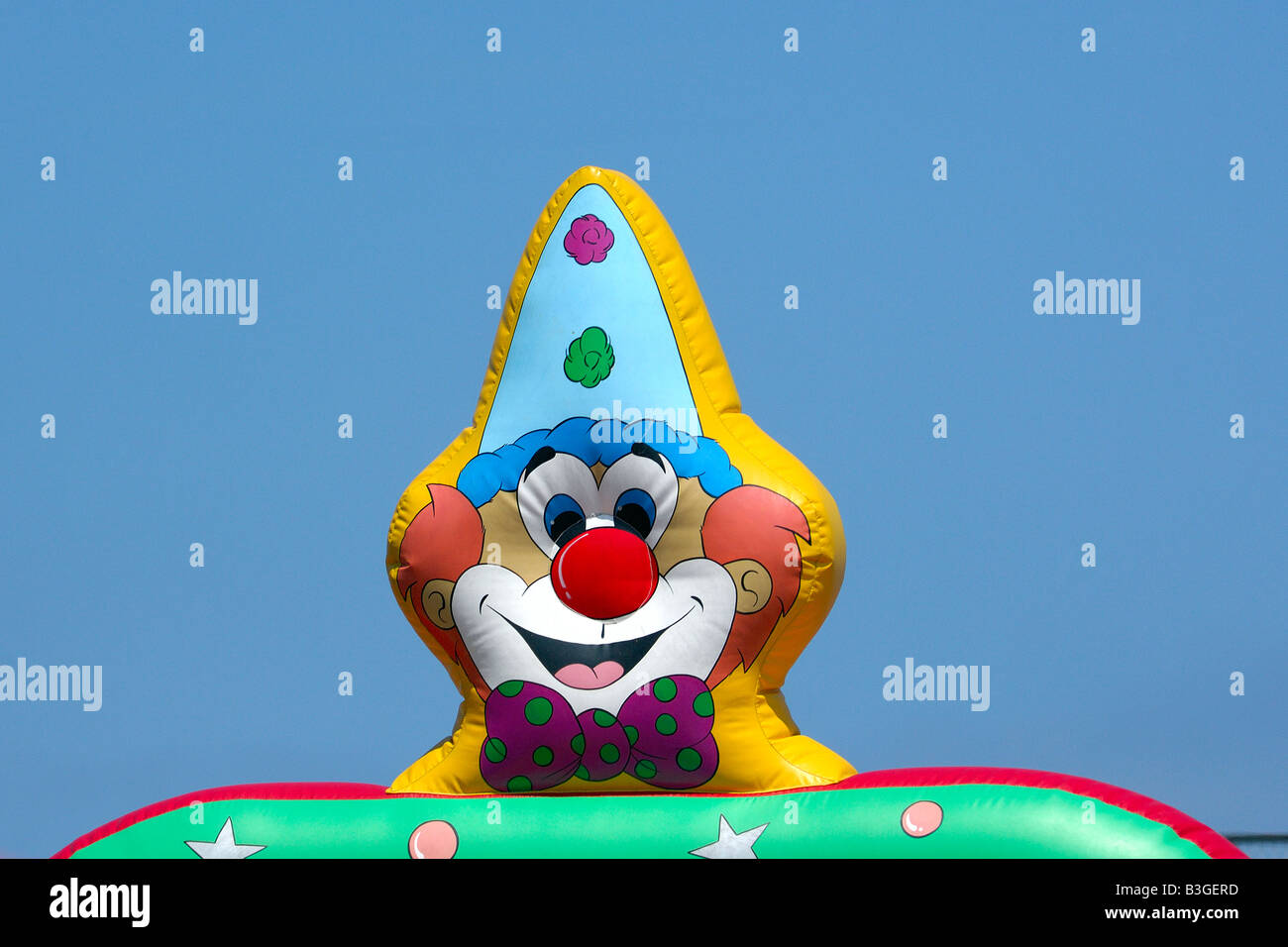 Clowns colorés sur la tête de d'un château gonflable gonflable à un champ de foire Banque D'Images