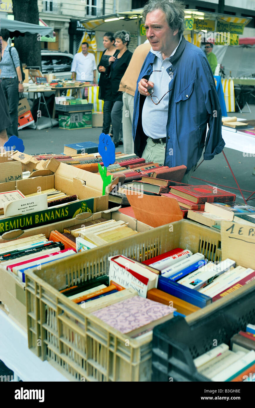 Paris France, Shopping marché aux puces, Seniors Old Man, regarder les livres à collectionner exposés dans le marché public Banque D'Images