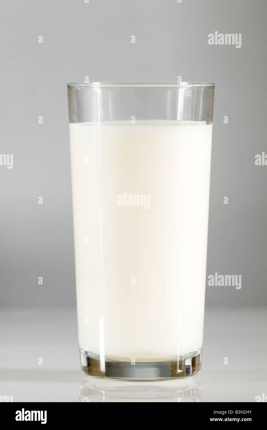 Plein verre de lait faible en gras sur une surface blanche Banque D'Images