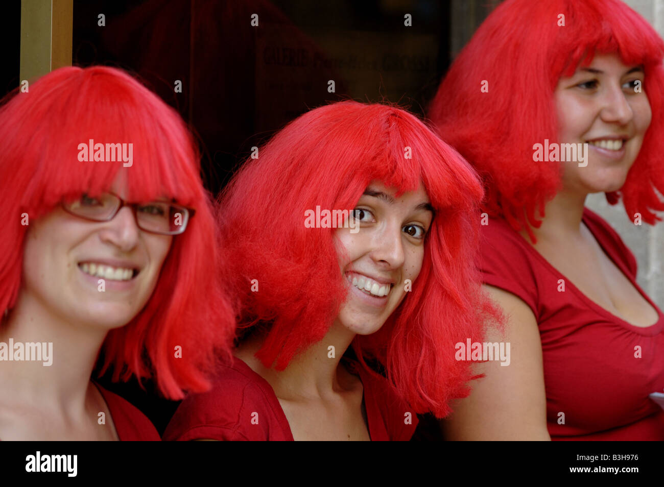 Trois jeunes femmes souriant vêtu de rouge à Avignon, France. Banque D'Images