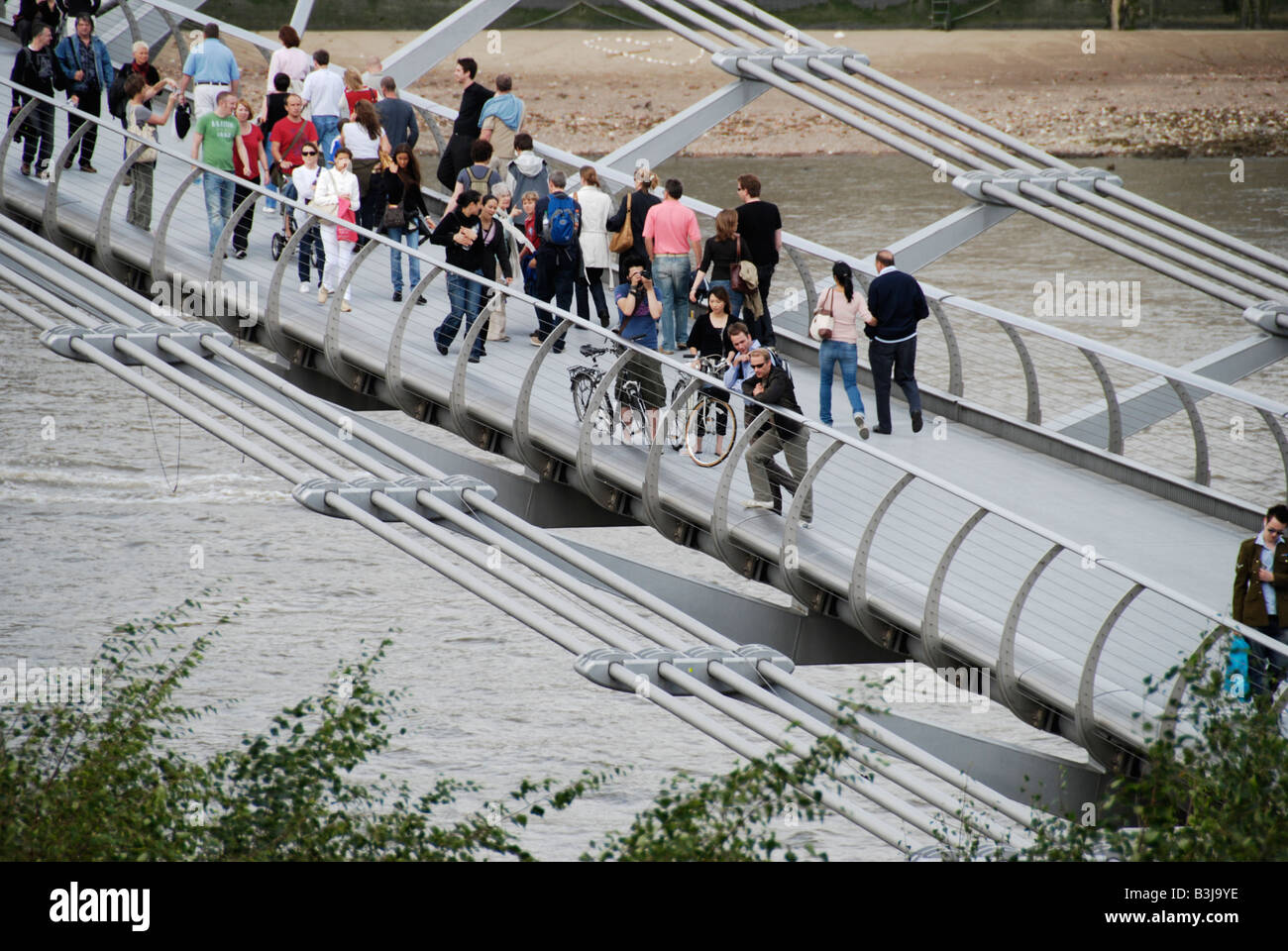 Les touristes sur le Millennium Bridge London England Banque D'Images