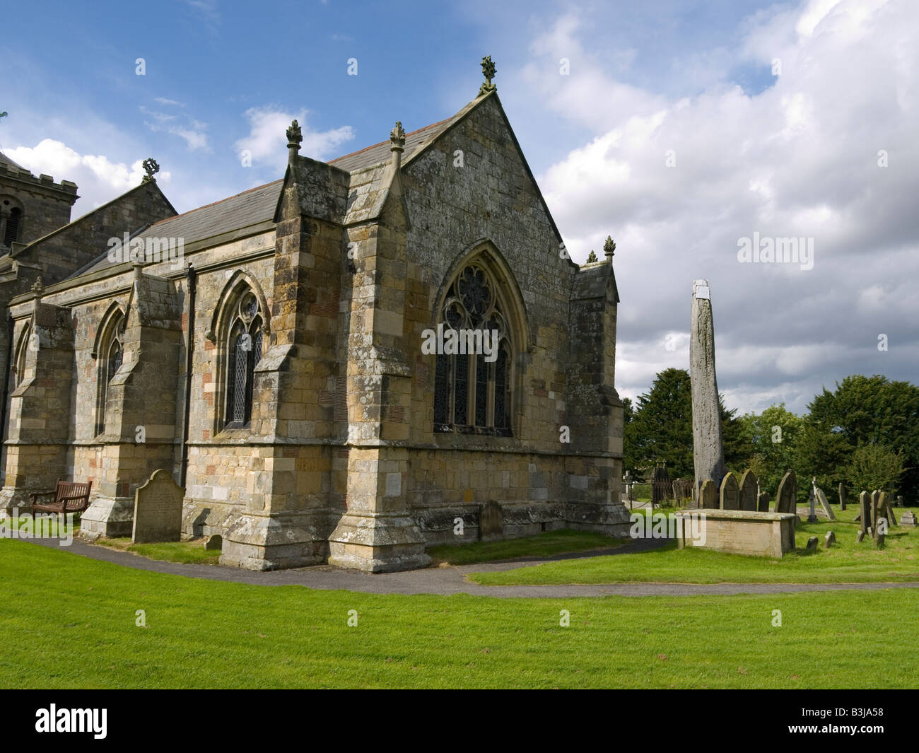 L'église à Rudston East Yorkshire avec un monolithe ancien 76 mètres de haut dans le cimetière Banque D'Images