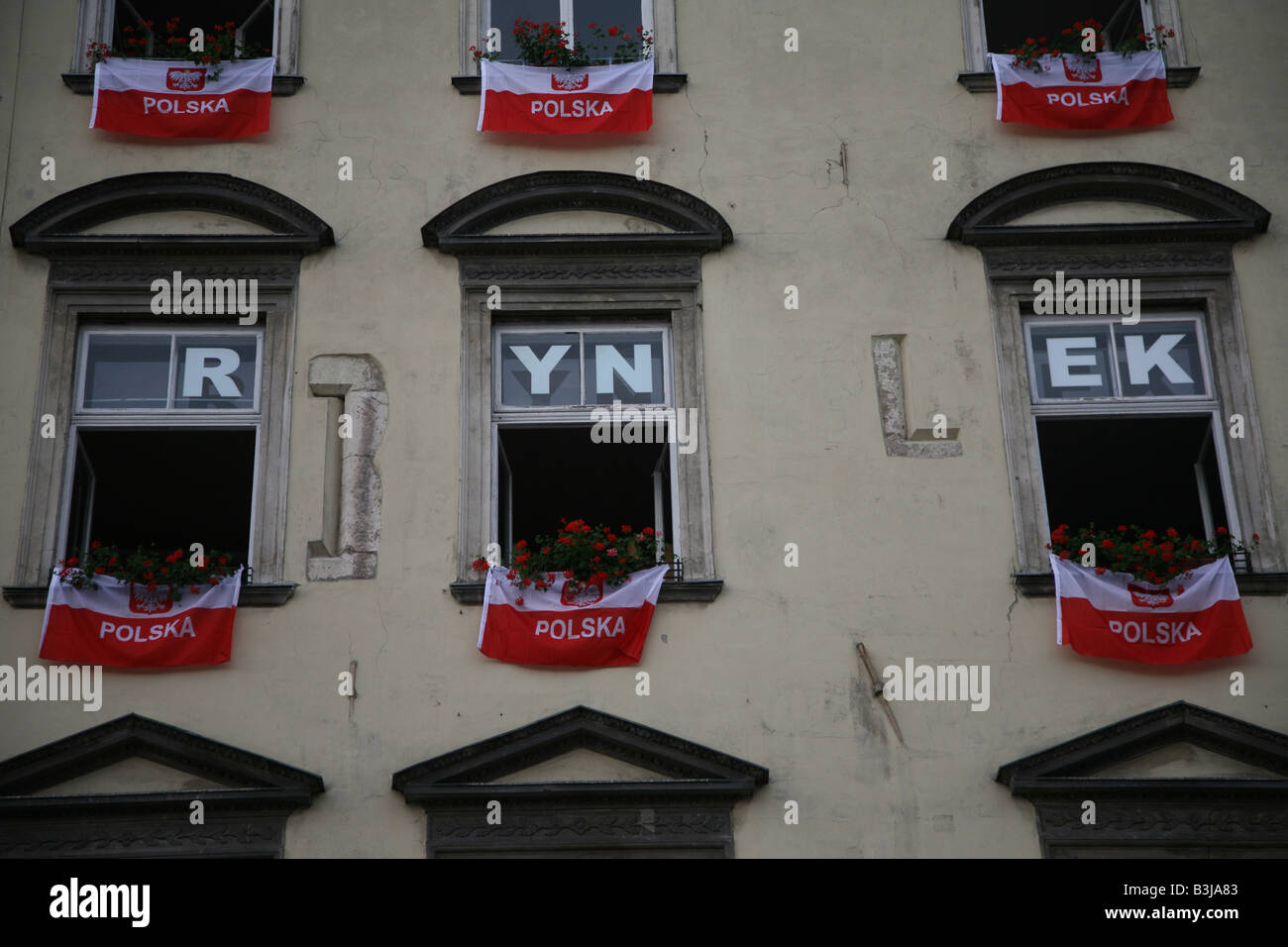 Drapeaux polonais suspendu à des capacités en place du marché, Rynek, Cracovie, Pologne Banque D'Images