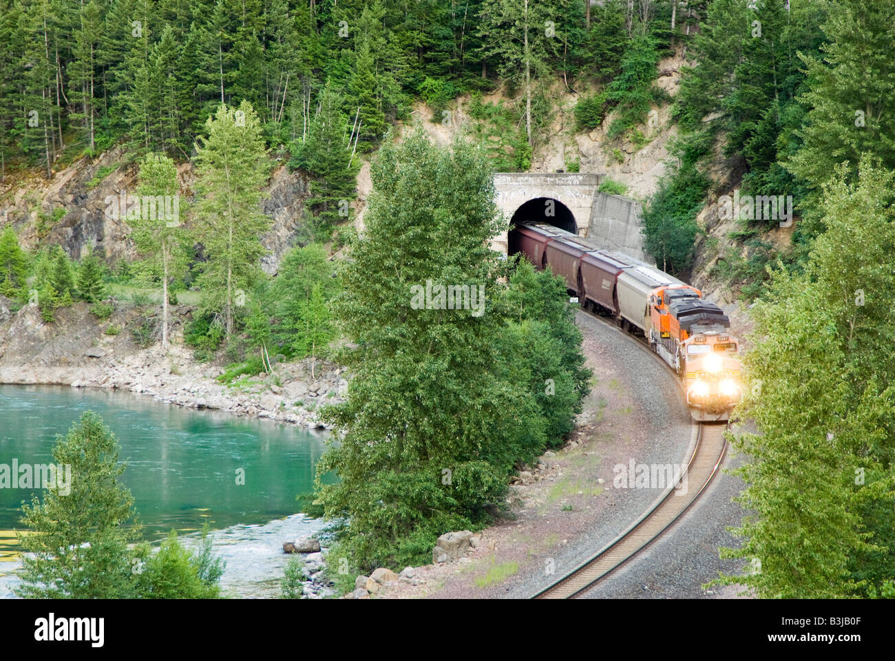 Un train de marchandises diesel électrique sortant d'un tunnel dans les montagnes du Montana le long de la rivière Middle Fork Banque D'Images