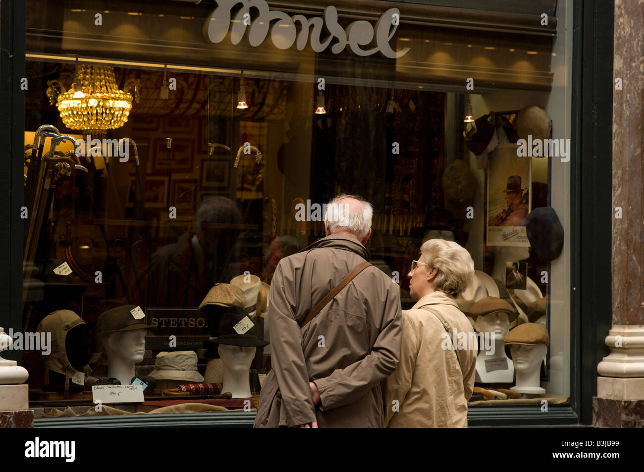 Un couple de personnes âgées regardez dans la fenêtre de l'ombrelle traditionnelle et hat shop dans le Royal Galeries St-hubert, Bruxelles, Banque D'Images