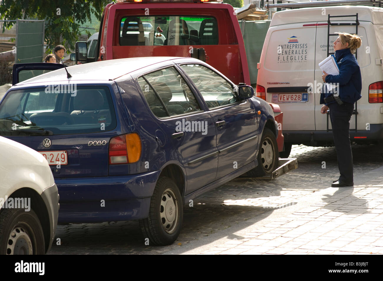 Femme regardant une voiture de police d'être remorqué à Bruxelles, Belgique Banque D'Images