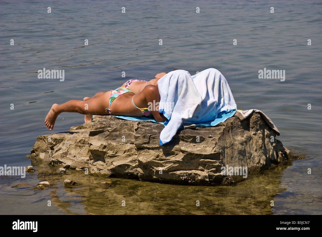Lac d'eau de plaine, plaine mer pierre falaise, rocher escarpé de l'heure d'été d'été marée Italie Ombrie deux personnes pour prendre le soleil bikini bat Banque D'Images