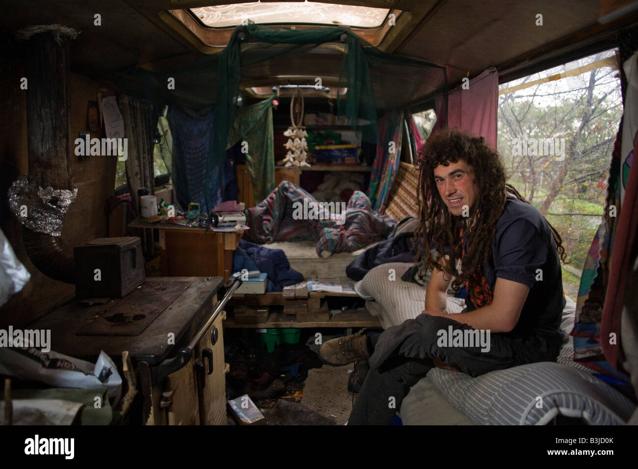 'Activiste' Hoosie aka Robert House se trouve dans son autobus-devenu-home tôt un dimanche matin à l'Faslane Peace Camp Banque D'Images