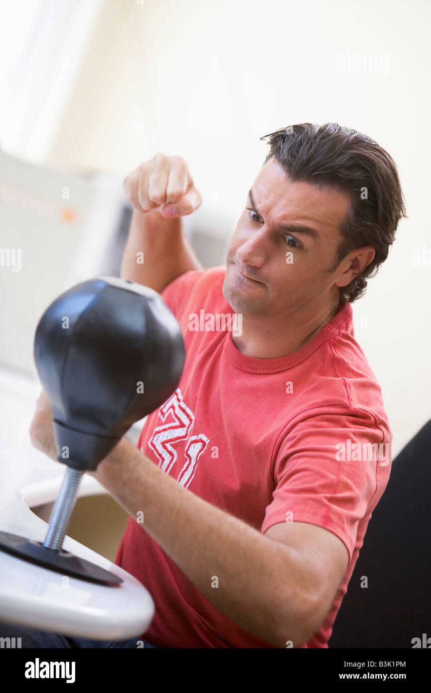 Businessman in office à l'aide de petits punching bag pour soulager le stress Banque D'Images