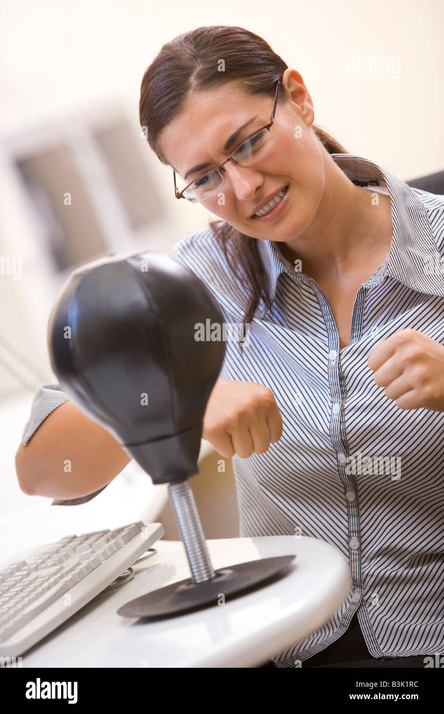 Femme en salle informatique à l'aide de petits punching bag pour le soulagement du stress Banque D'Images