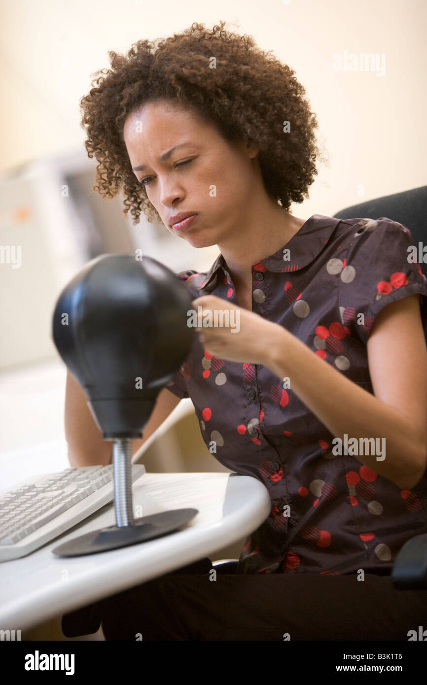 Femme assise dans la salle informatique d'une petite frappe punching bag Banque D'Images