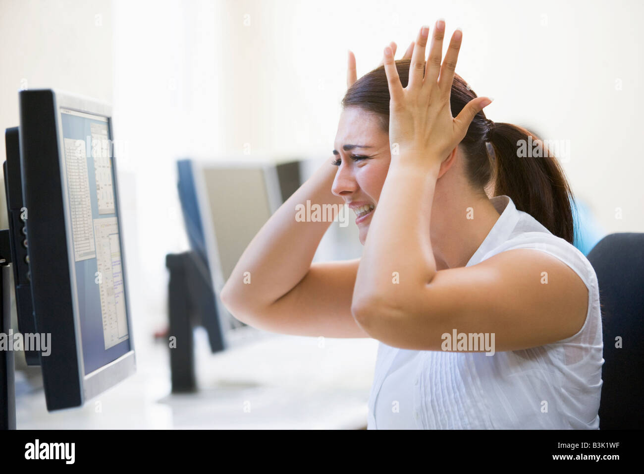 Femme dans la salle informatique à la frustration Banque D'Images