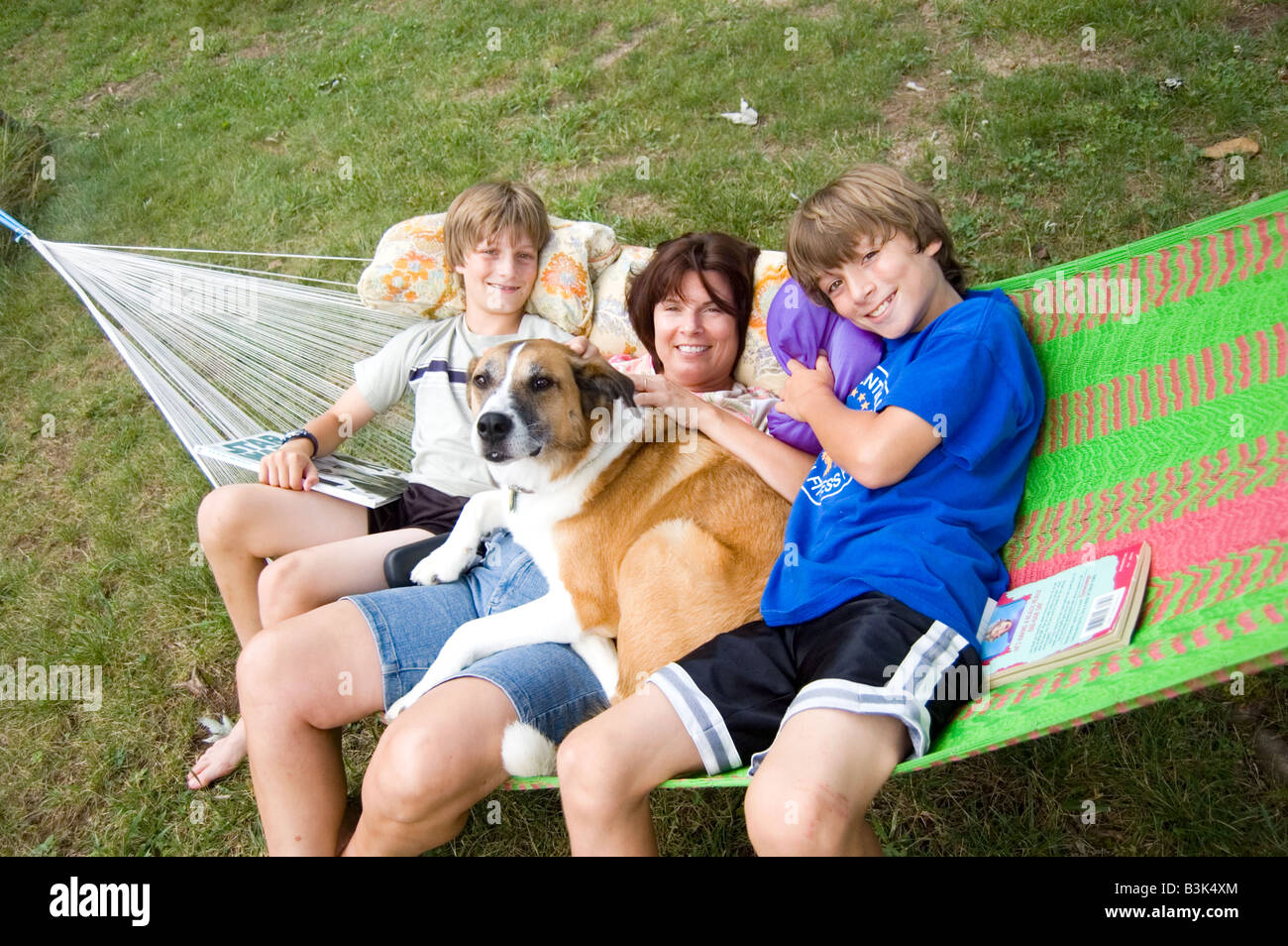 Mère, fils et chien lounge ensemble dans un hamac dans la cour arrière Banque D'Images
