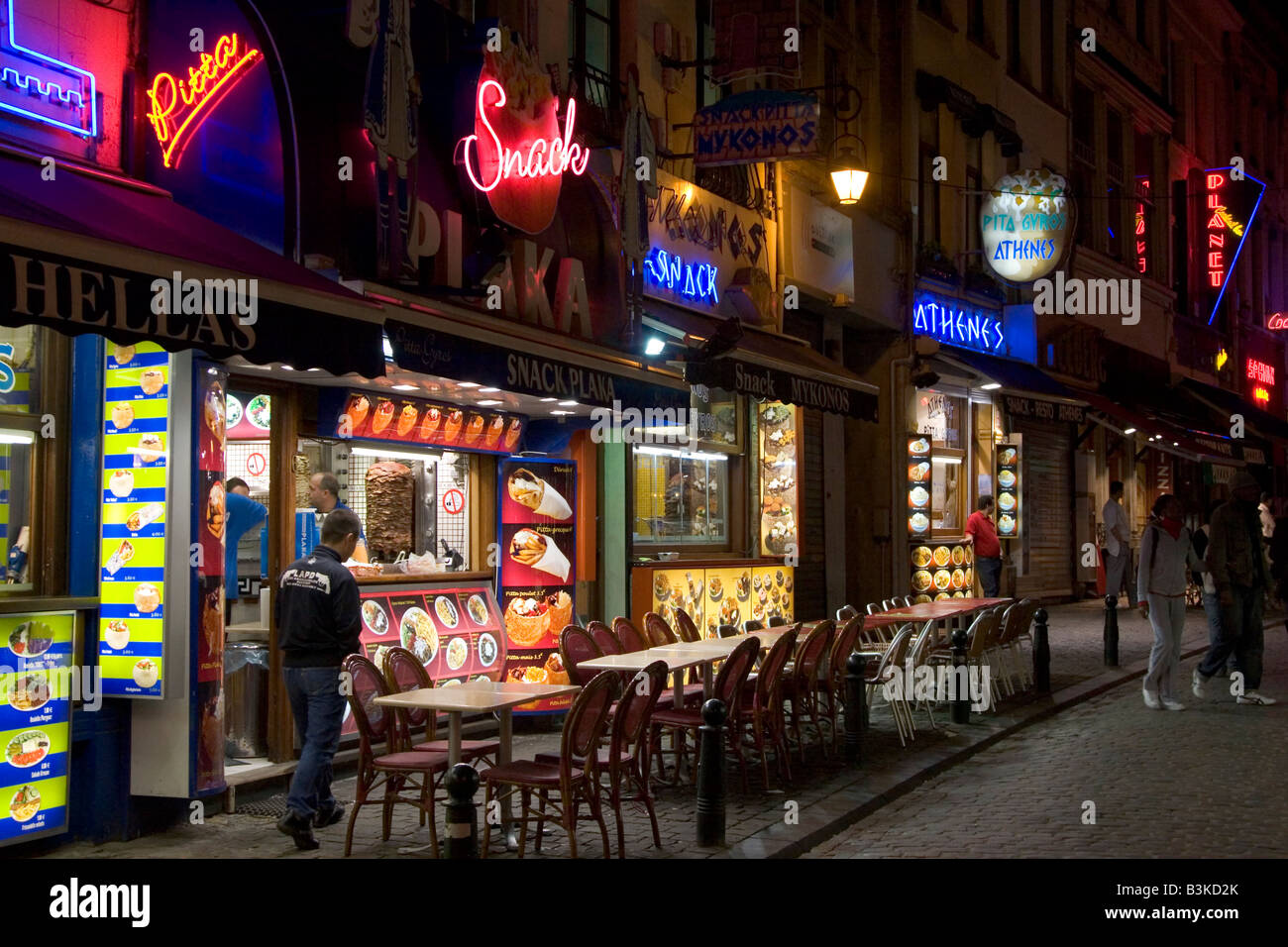 La nuit vue de la boutique néon fronts de fast food restaurants le long de la petite rue des