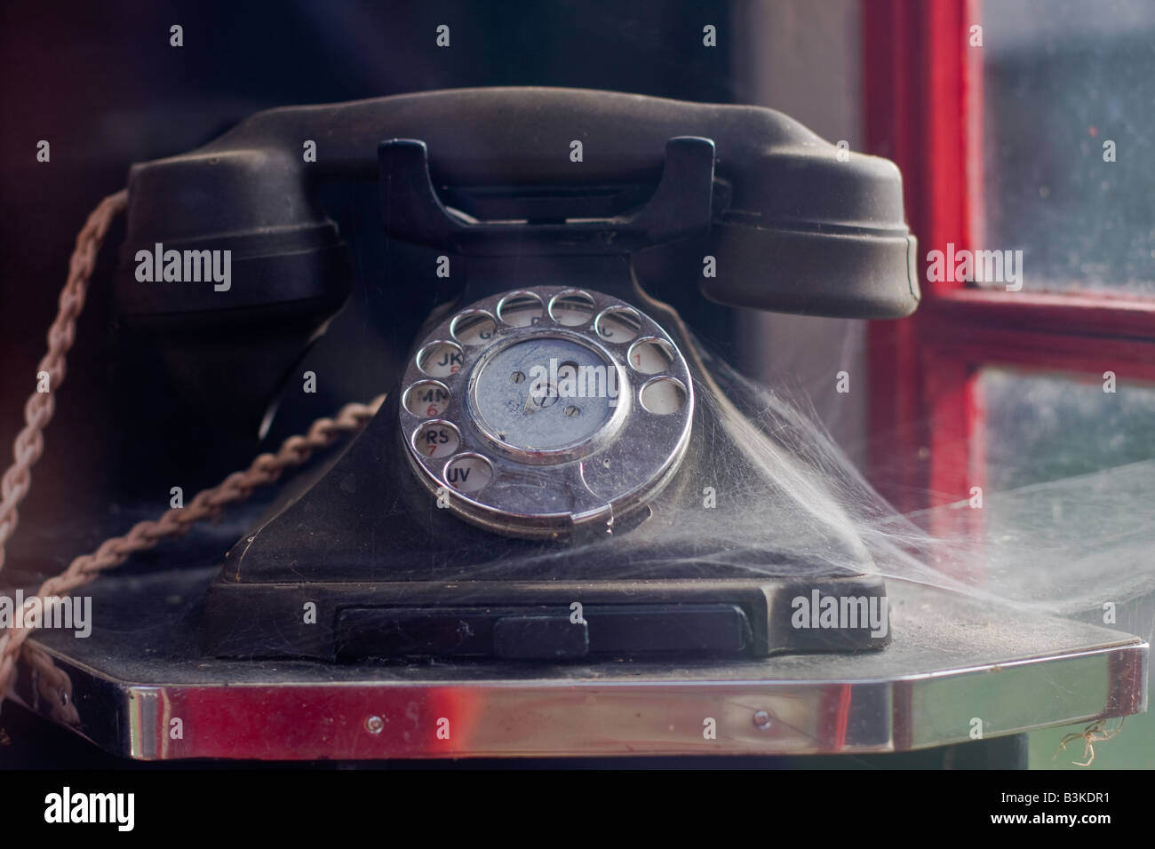 Ancien téléphone en bakélite noire avec d'araignée dans le vieux téléphone rouge fort avec cadran de doigt, Tyneham Village, Dorset Banque D'Images