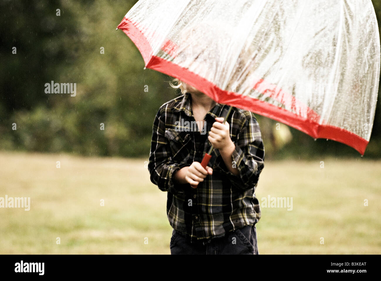 Un garçon avec un grand parapluie. Banque D'Images